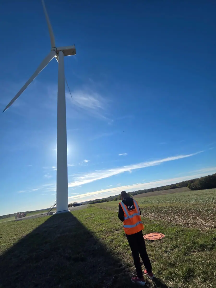 Stagiaire au pied d’une éolienne
